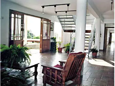 a living room with a chair and a staircase at Hotel Terrazas del Rincon in Merlo