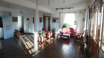 a living room with red chairs and a table at Hotel Terrazas del Rincon in Merlo