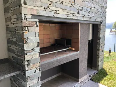 an outdoor oven with a stone wall at Casonas de la Bahia in Villa Carlos Paz