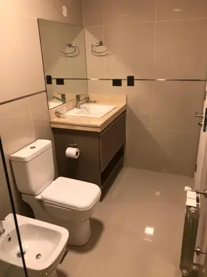 a bathroom with a toilet and a sink and a mirror at Casonas de la Bahia in Villa Carlos Paz
