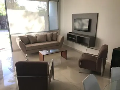 a living room with a couch and a tv at Casonas de la Bahia in Villa Carlos Paz