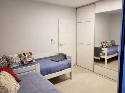 a bedroom with two beds and a mirror at Torre del Lago I in Villa Carlos Paz