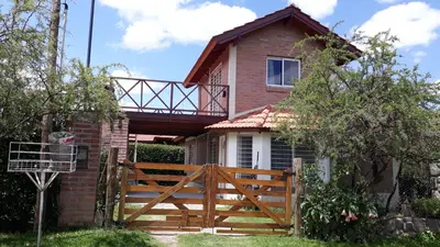 a house with a wooden fence in front of it at Bosysol en las sierras in Merlo
