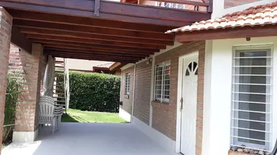 a wooden pergola over a walkway to a house at Bosysol en las sierras in Merlo