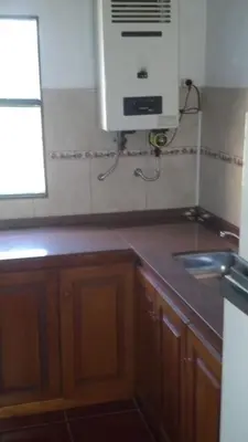 a kitchen with a sink and a air conditioner on the wall at Cabañas las Vertientes in Villa Parque Siquiman