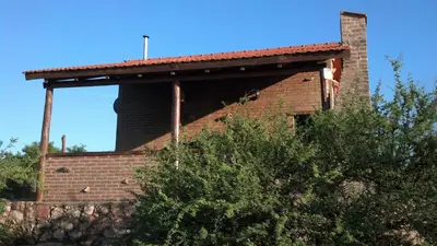 a brick building with a chimney on the side of it at Cabañas las Vertientes in Villa Parque Siquiman