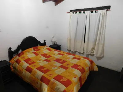 a bedroom with a bed with a colorful quilt at Cabañas las Vertientes in Villa Parque Siquiman