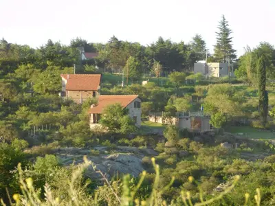 a group of houses on a hill with trees at Cabañas las Vertientes in Villa Parque Siquiman