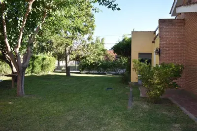 a yard next to a brick building with trees at Dos ruedas in Mina Clavero