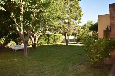 a park with a bench and trees in the grass at Dos ruedas in Mina Clavero