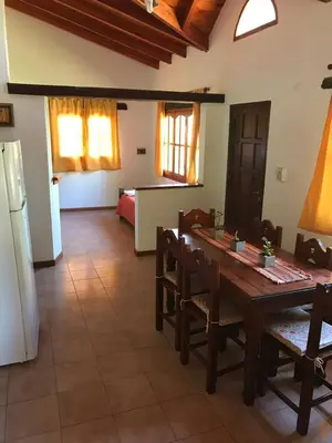 a kitchen and dining room with a table and chairs at Cabañas Luz de Luna in Santa Rosa de Calamuchita