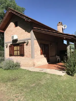 a brick house with a porch and a patio at Cabañas Luz de Luna in Santa Rosa de Calamuchita