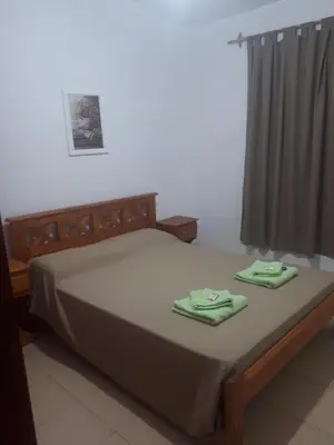 a bed with two green towels on top of it at Complejo LUMA, Con Pileta in Villa Dolores