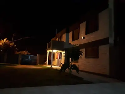 a house lit up at night with a building at Complejo LUMA, Con Pileta in Villa Dolores