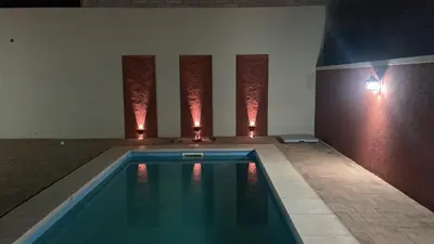 a swimming pool in a room with lights on the wall at Complejo LUMA, Con Pileta in Villa Dolores