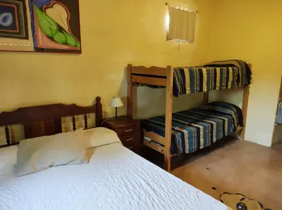 a bedroom with two bunk beds and a bed at Casa Amarilla in Mina Clavero