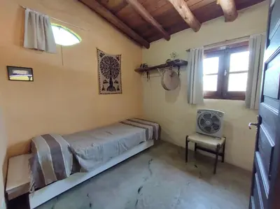 a small bedroom with a bed and a window at Casa Amarilla in Mina Clavero