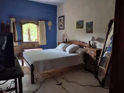 a blue bedroom with a bed and a window at Casa Amarilla in Mina Clavero