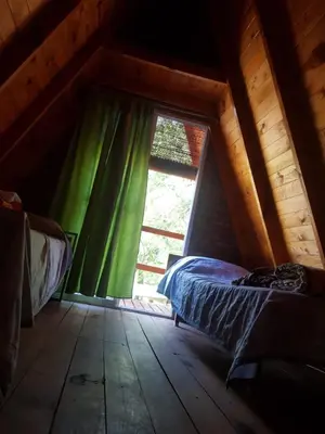 a bedroom with a bed and a window in a attic at Cabañas Pancho Segunda Usina in Embalse