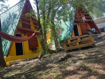 a house with a hammock in front of it at Cabañas Pancho Segunda Usina in Embalse