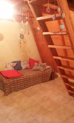 a room with a large couch in a attic at Cabañas Pancho Segunda Usina in Embalse