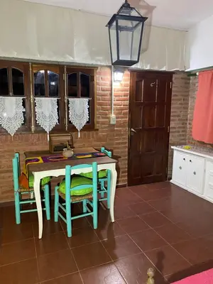 a kitchen with a table and some chairs and a light at Cerro Chico Brochero in Villa Cura Brochero