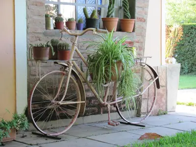 an old bike parked next to a wall with potted plants at Cerro Chico Brochero in Villa Cura Brochero