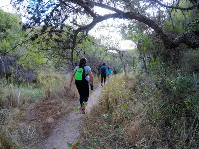 two people walking on a trail in the woods at Cerro Chico Brochero in Villa Cura Brochero
