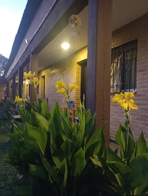 a house with yellow flowers in front of it at Posada Entre Dos in Mina Clavero