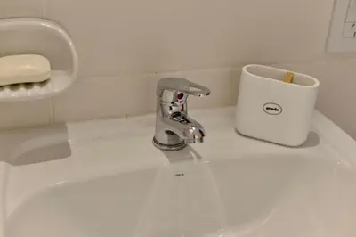 a white sink with a toothbrush in a cup on it at 370 General Simón Bolívar in Cordoba