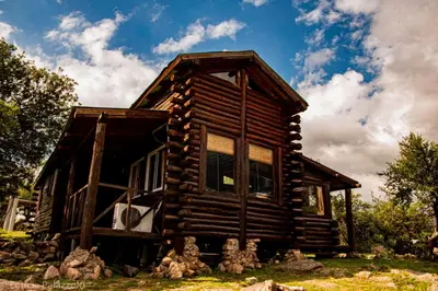 a log cabin house with a sky background at Cabaña de Troncos en la montaña in Mina Clavero