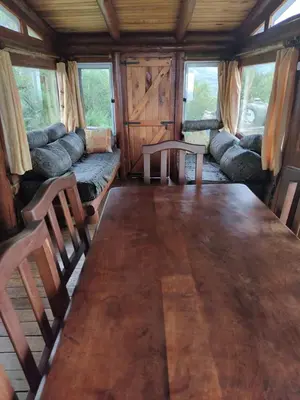 a dining room with a large wooden table and chairs at Cabaña de Troncos en la montaña in Mina Clavero