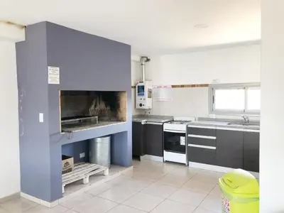 a large kitchen with a stove and a sink at VILLA MIA in Villa Carlos Paz