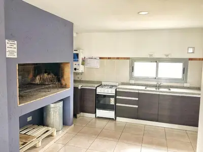 a kitchen with a stove and a fireplace in it at VILLA MIA in Villa Carlos Paz