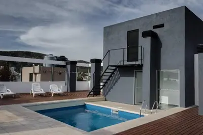 a house with a swimming pool and a balcony at VILLA MIA in Villa Carlos Paz