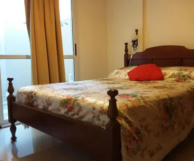 a bedroom with a bed with a red pillow on it at MIralejos II in Villa Carlos Paz