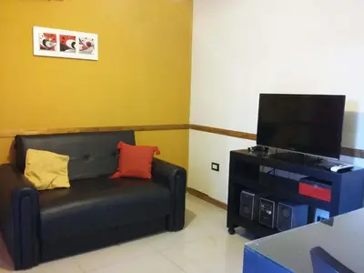 a living room with a couch and a flat screen tv at MIralejos II in Villa Carlos Paz