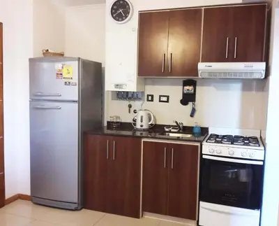 a kitchen with a stainless steel refrigerator and wooden cabinets at MIralejos II in Villa Carlos Paz