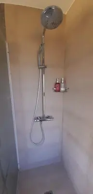 a shower with a shower head in a bathroom at La Macarena Suites in Villa General Belgrano
