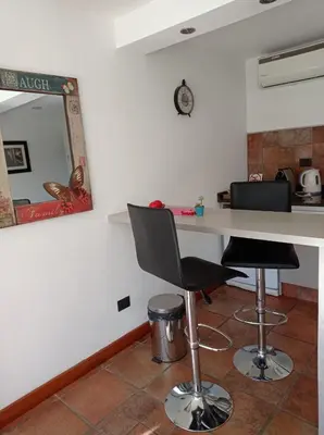 a kitchen with a table and two chairs and a mirror at La Macarena Suites in Villa General Belgrano