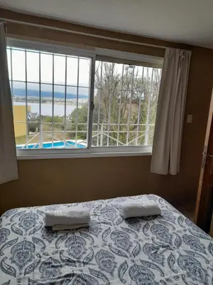 a bedroom with a bed and a large window at Casa en Playa Perelli in Villa Carlos Paz