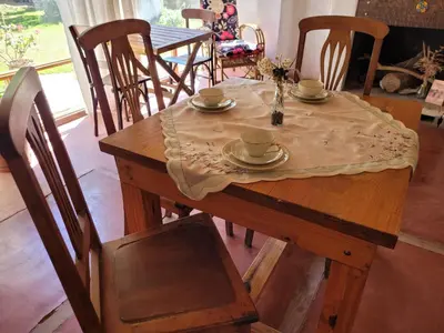 a wooden table with cups and saucers on it at Hostal Antigua Casa Criolla in Los Reartes