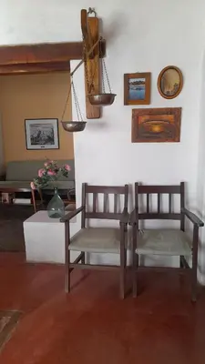 two chairs and a table in a living room at Hostal Antigua Casa Criolla in Los Reartes