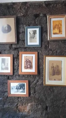 a wall with framed pictures on a stone wall at Hostal Antigua Casa Criolla in Los Reartes