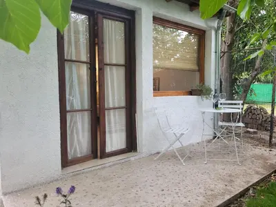 a patio with a table and chairs in front of a window at Hostal Antigua Casa Criolla in Los Reartes
