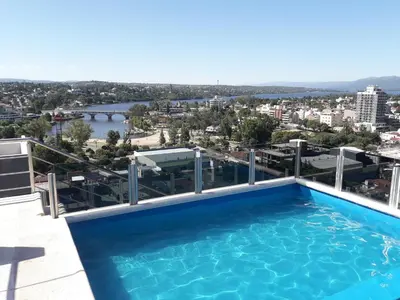 a swimming pool on the roof of a building with a view at Dpto Teatro Melos microcentro pileta y cochera in Villa Carlos Paz