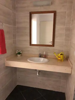 a bathroom with a sink and a mirror at Dpto Teatro Melos microcentro pileta y cochera in Villa Carlos Paz