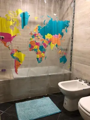 a bathroom with a mural of a world on the shower curtain at Dpto Teatro Melos microcentro pileta y cochera in Villa Carlos Paz