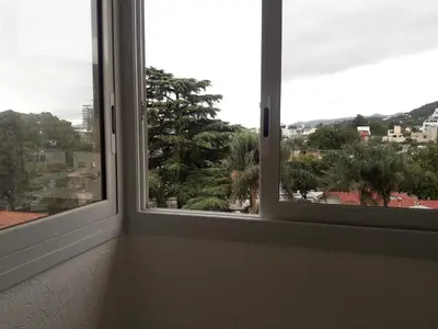 an empty room with two windows with a view at Dpto Teatro Melos microcentro pileta y cochera in Villa Carlos Paz