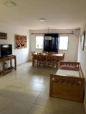 a living room with a table and a dining room at Dpto Teatro Melos microcentro pileta y cochera in Villa Carlos Paz